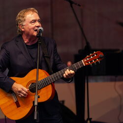 Klaus Hofmann im schwarzen Anzug an der Gitarre.